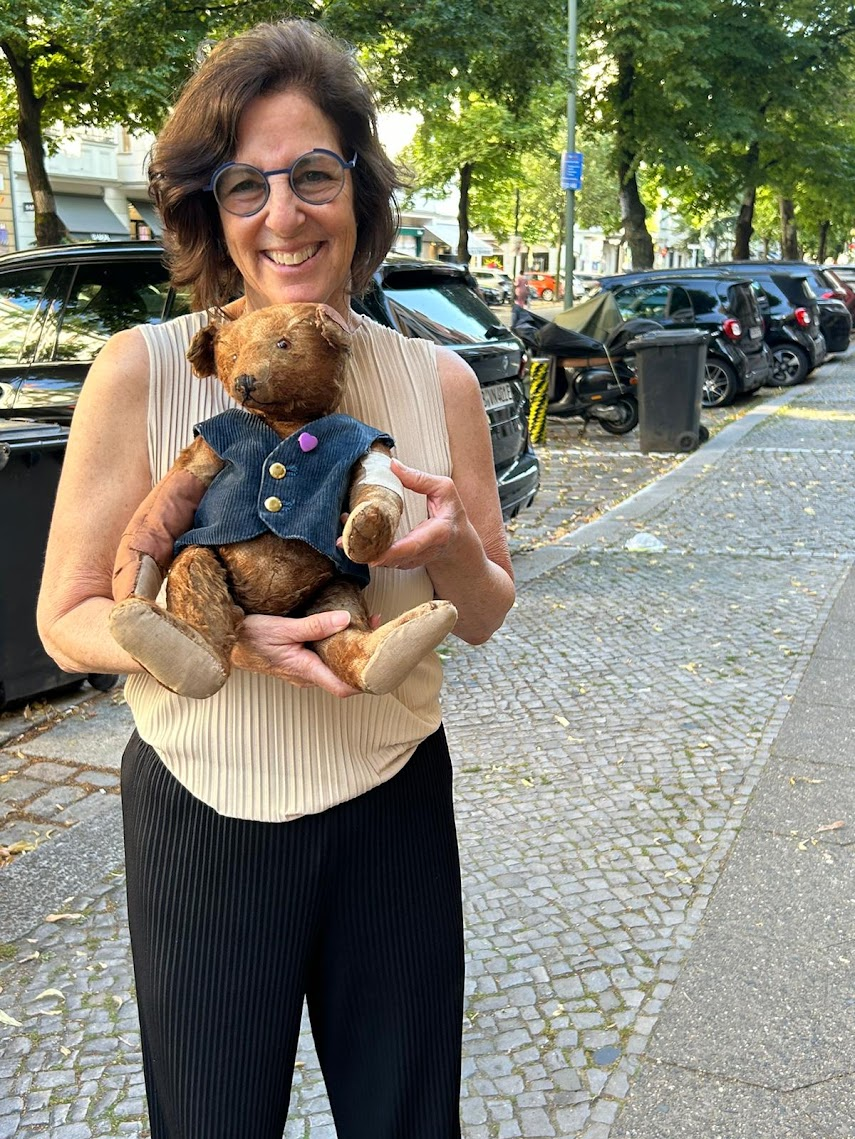 Author Jill Levenfeld smiling while holding Irene’s bear Bärchen on Schlüterstraße in Berlin